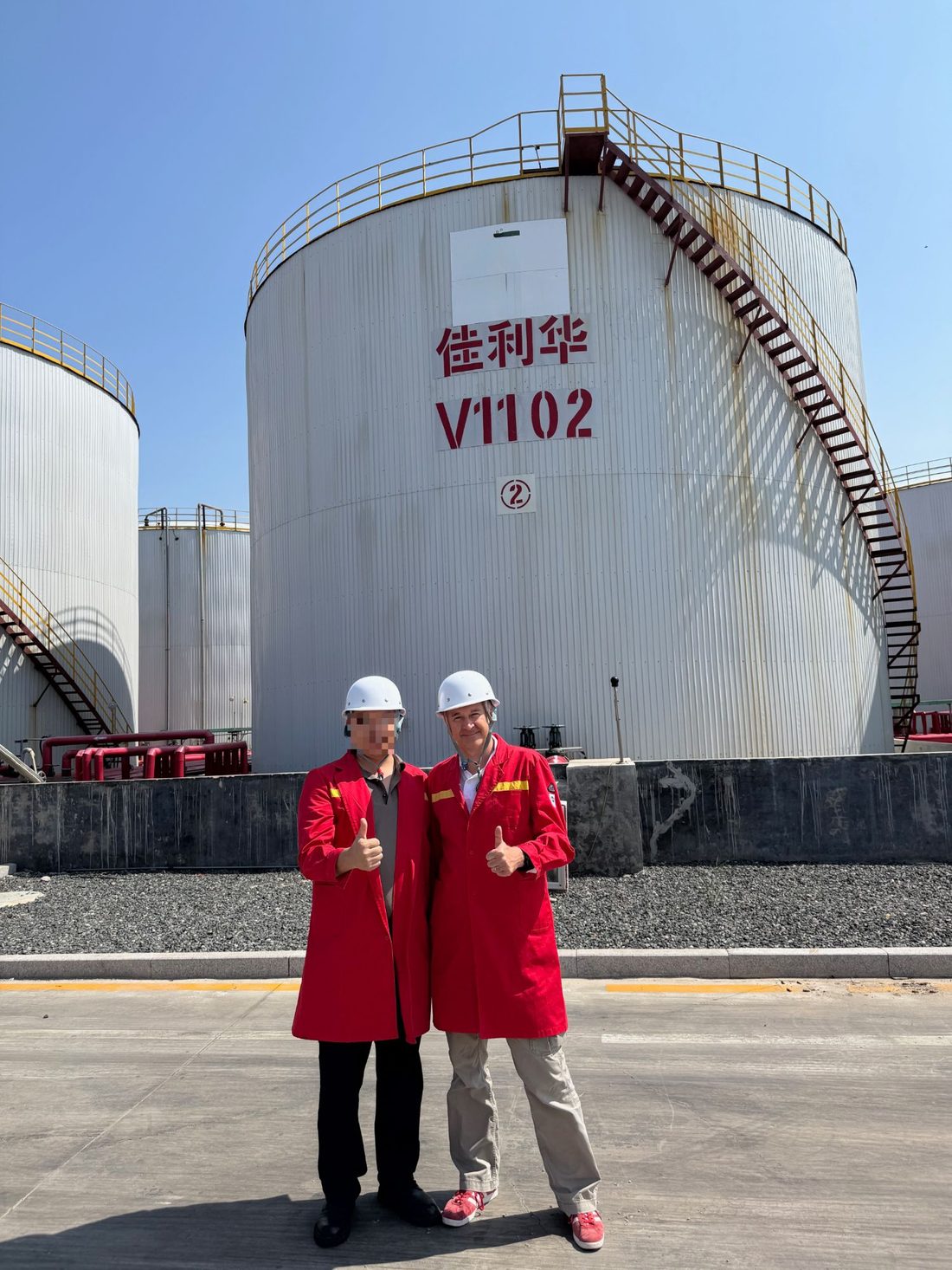 Patrick Rolland en tenue de sécurité devant un bac de stockage, lors d'une visite de terminal en Chine